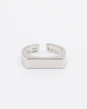 An adjustable silver ring with a rhodium finish and a rectangular bar design.