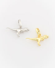 Silver and gold dinosaur-shaped pendants on a white background