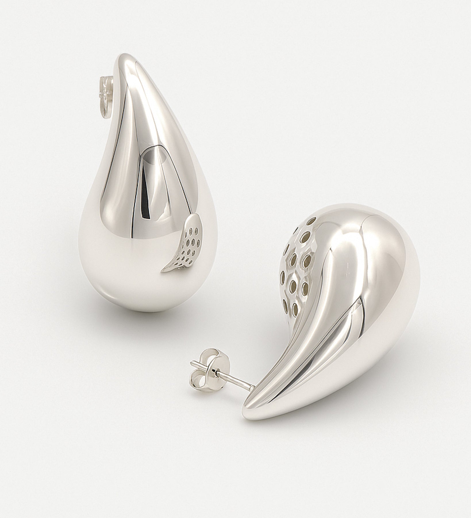 Pair of silver teardrop-shaped earrings on a white background