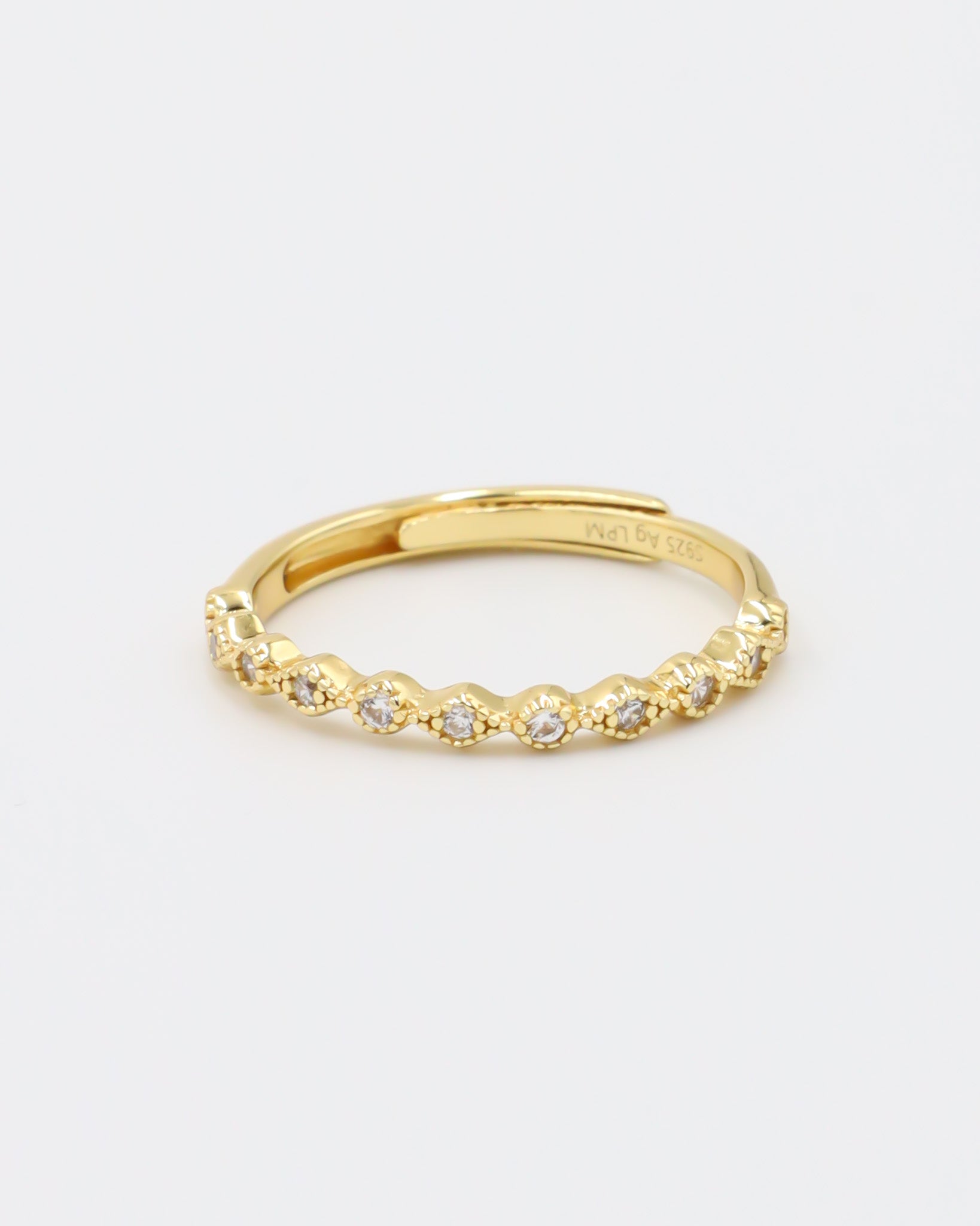 A gold-colored ring with multiple gemstones set around its circumference.