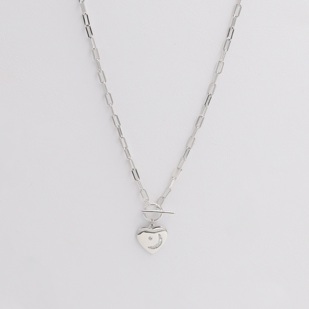 A silver necklace with a small charm pendant, displayed against a white background.