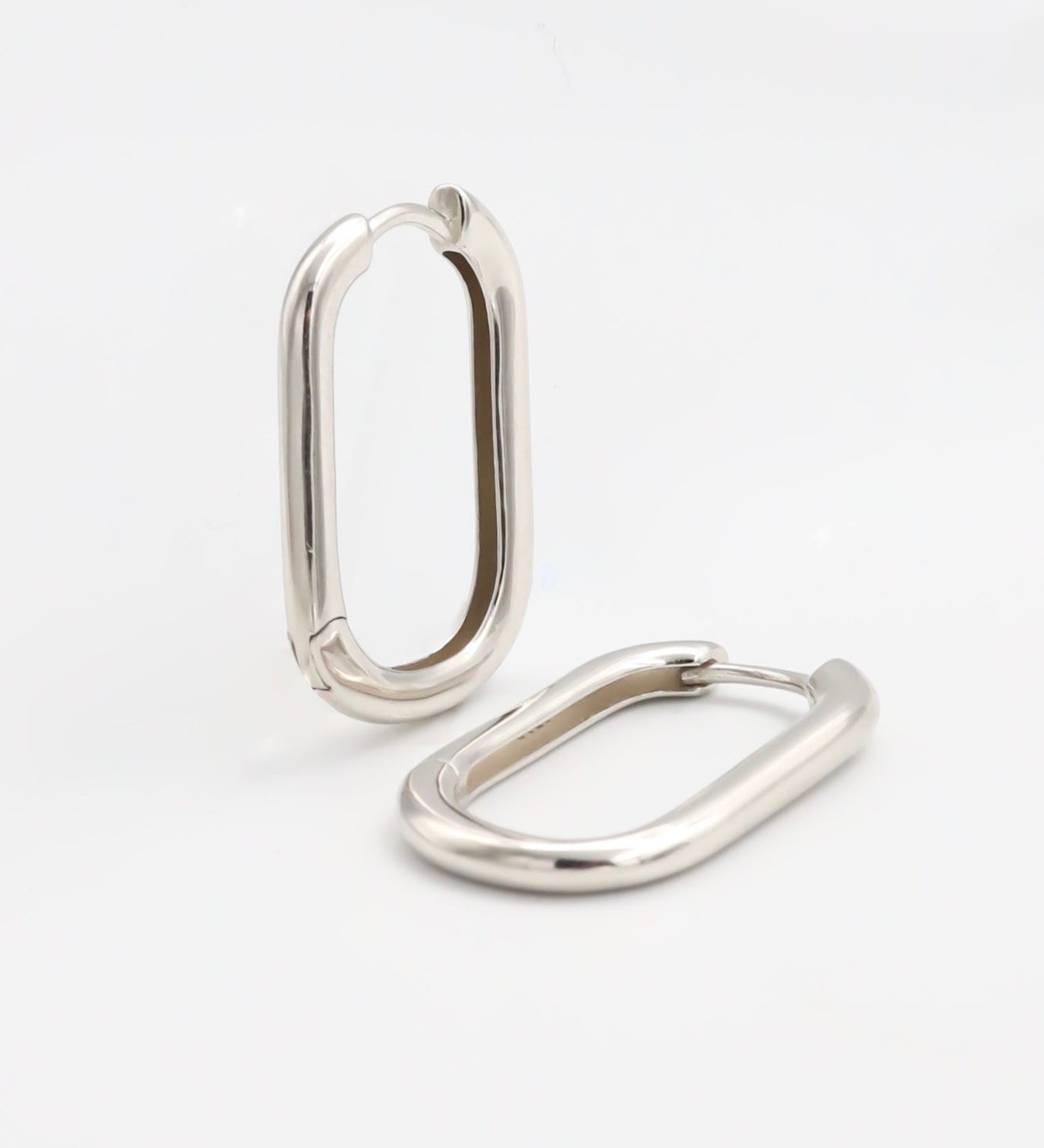 Two silver-colored metal belt buckles with a simple, classic design on a white background.