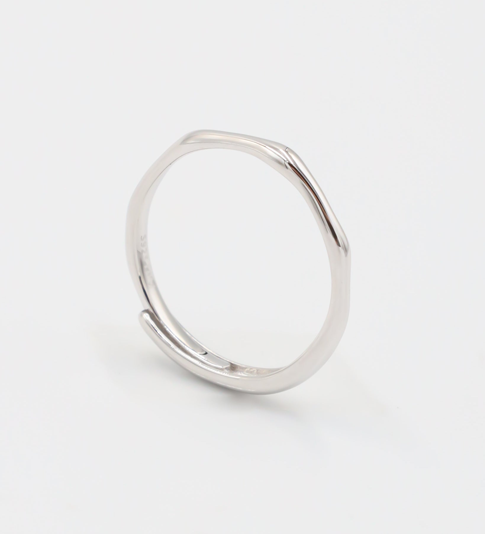 A silver ring standing on a white background.