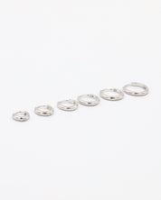 A series of circular silver colored hoops of varying sizes arranged in a line on a white background.