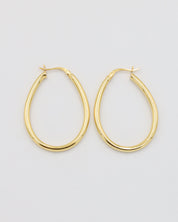 A pair of gold creole earrings with a latch back clasp on a white background.