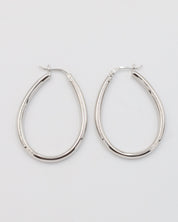 A pair of silver creole earrings with a latch back clasp on a white background.