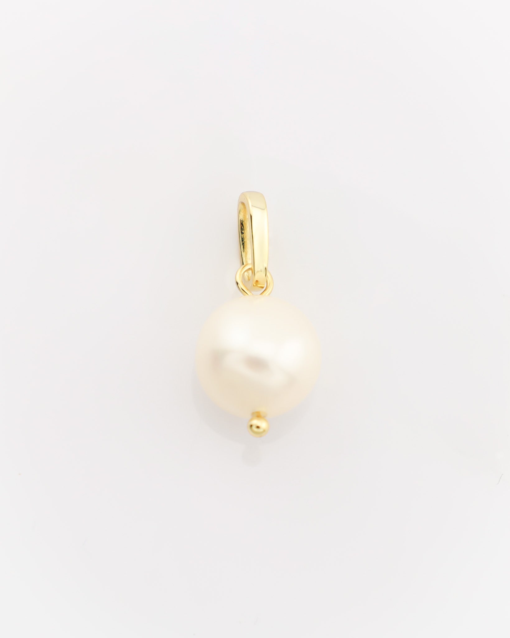 Gold pendant with a pearl on a light gray background
