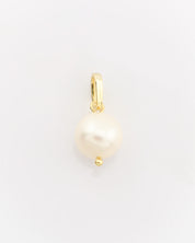 Gold pendant with a pearl on a light gray background