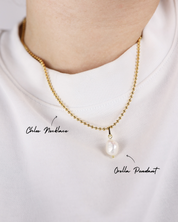 Gold necklace with a pearl pendant on a white background