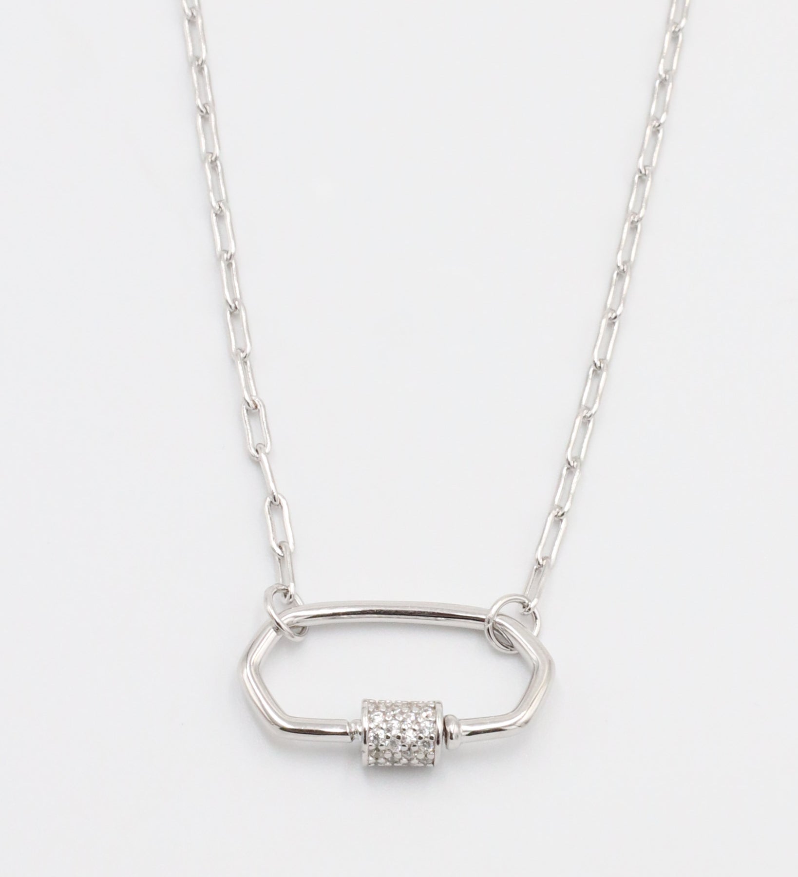 A silver necklace with a pendant featuring multiple stones in a geometric pattern.