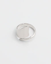 A silver ring with an abstract design on a white background.