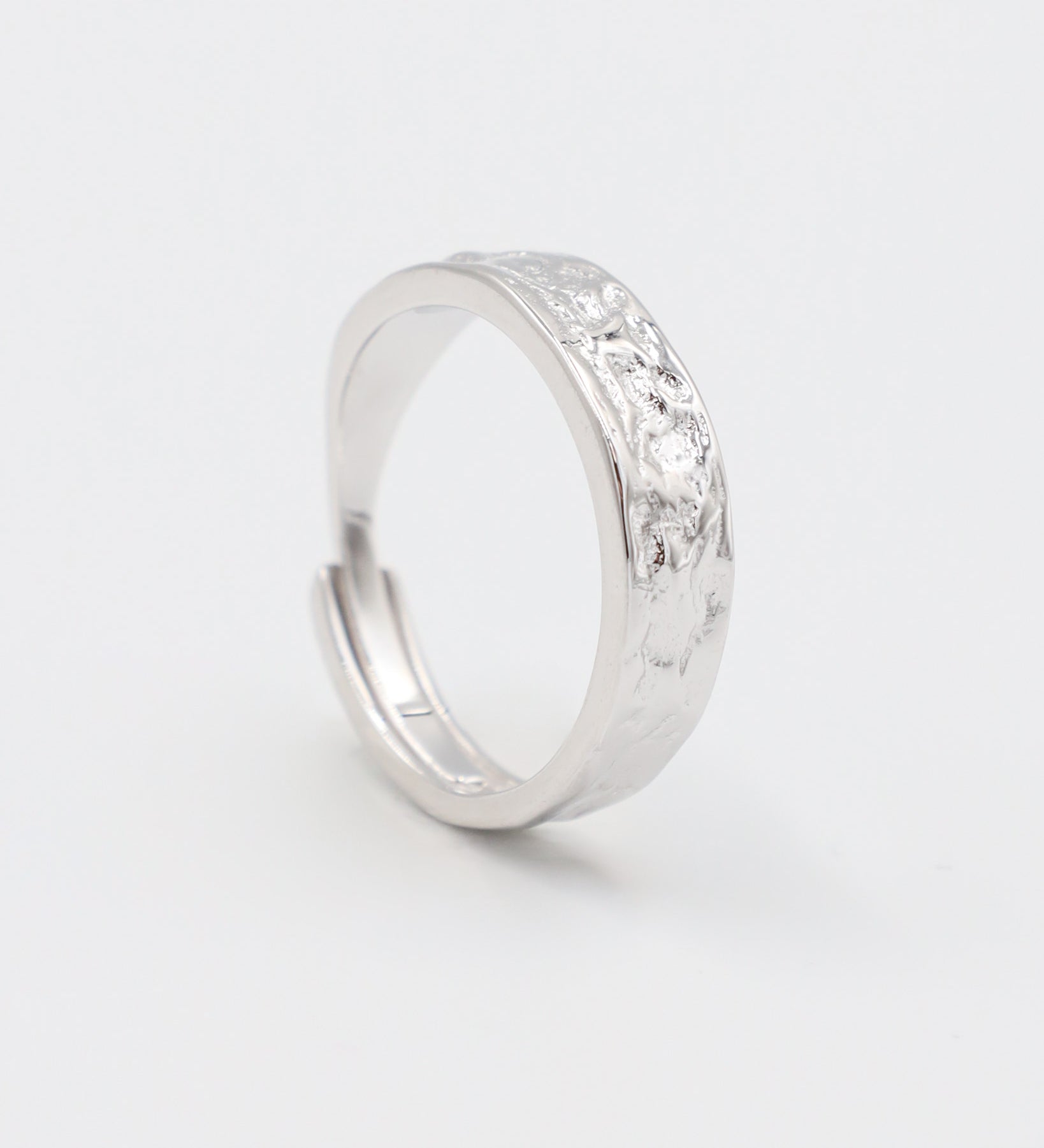 A simple silver ring with a textured surface, displayed against a white background.