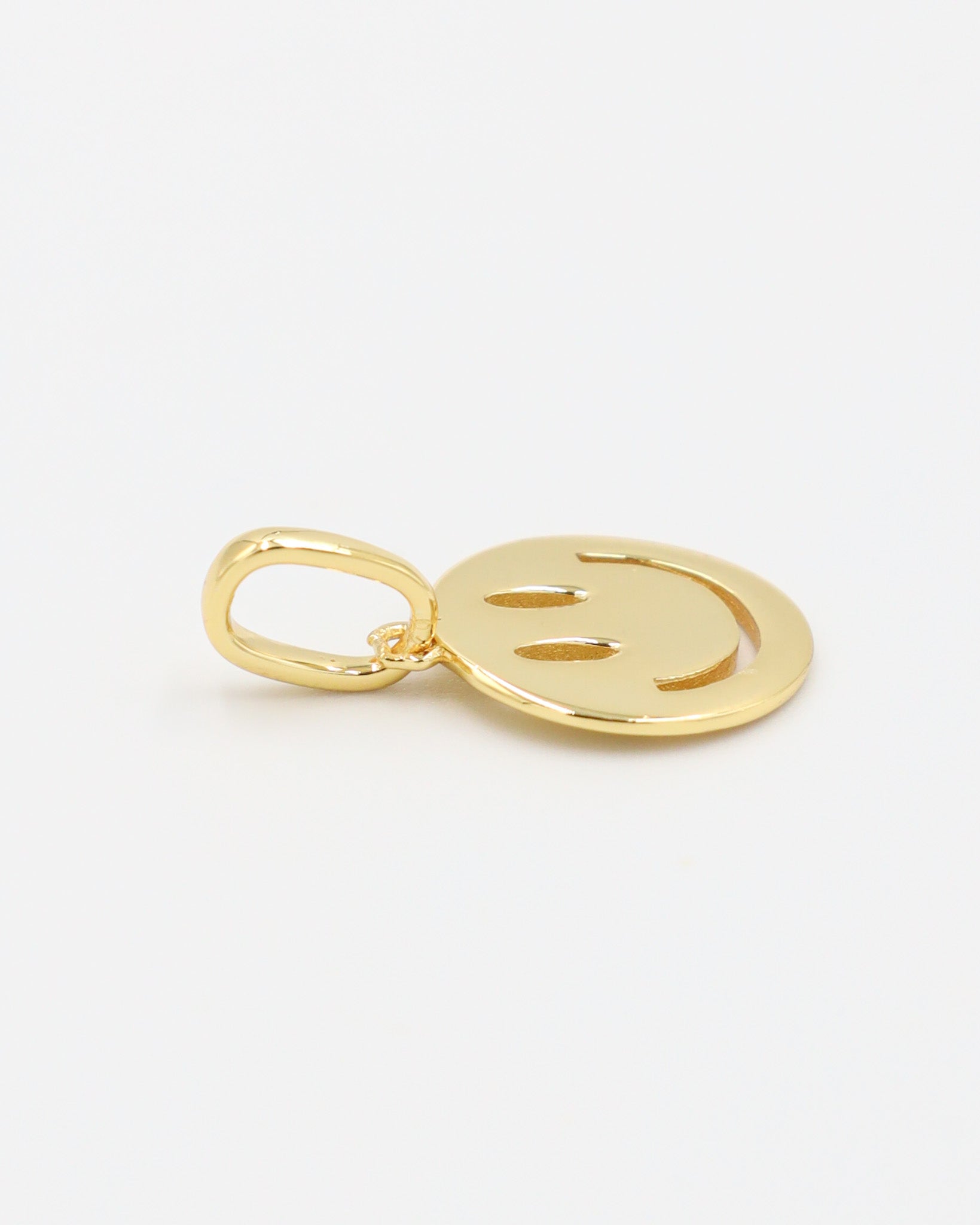 Flynn Gold smiley face pendant made of gold-plated 925 sterling silver, shown close-up with side view.