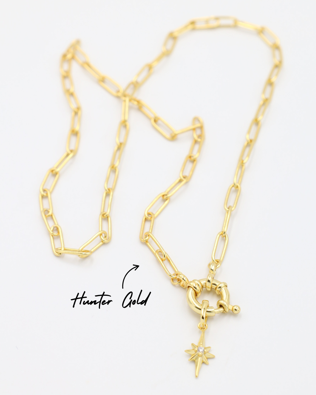 Gold star-shaped pendant with a zirconia stone, paired with a chain necklace.