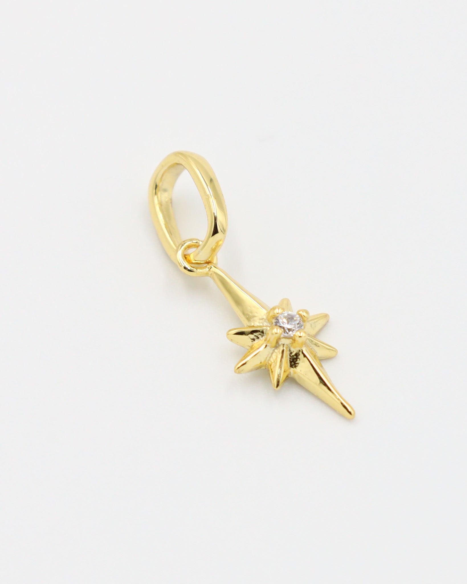Close-up of a gold star pendant, showcasing the zirconia stone centerpiece.