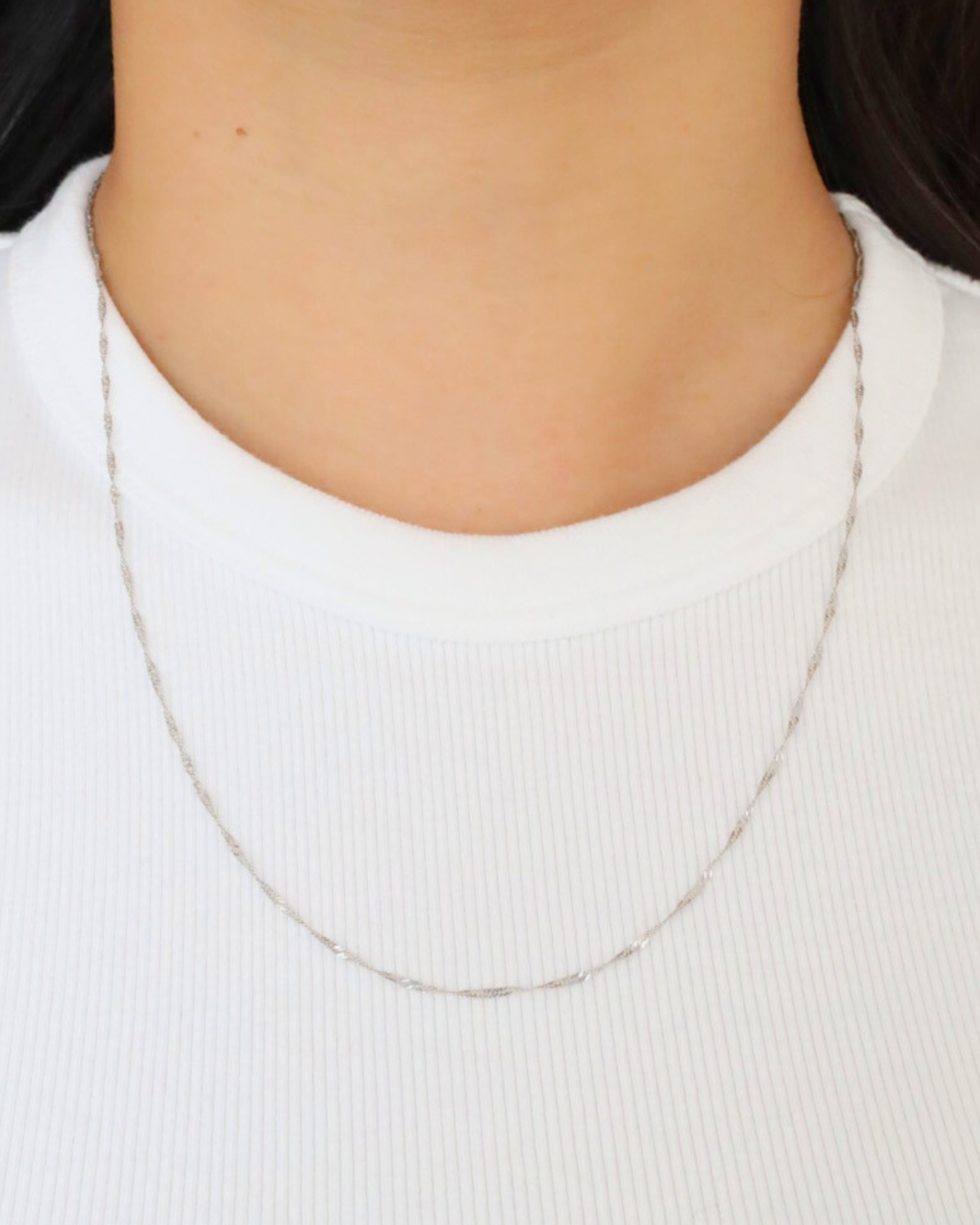 Woman wearing the delicate Jamie Silver necklace, made from 925 sterling silver.