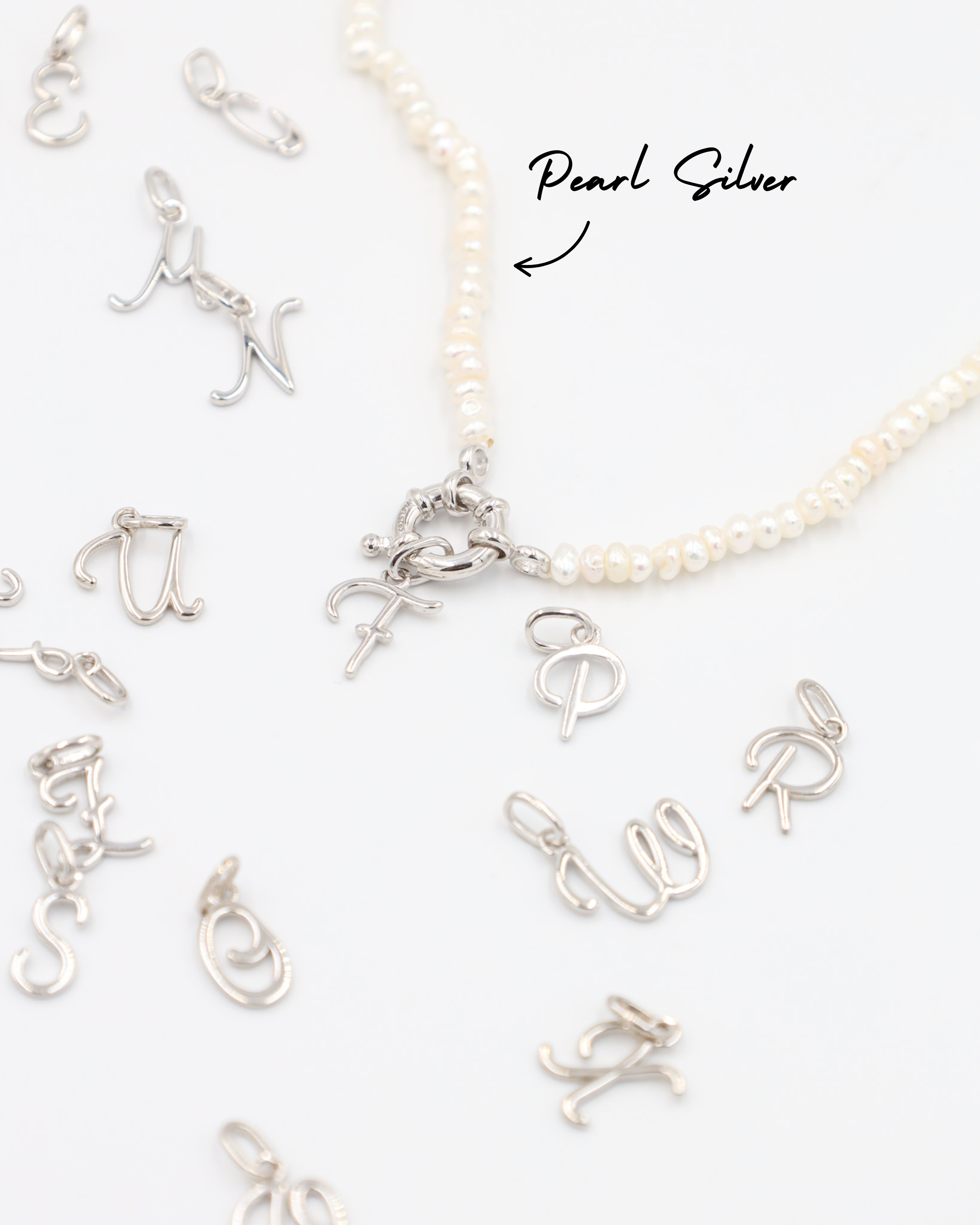 Rhodium plated 925 sterling silver letter curve pendants attached to a pearl necklace.