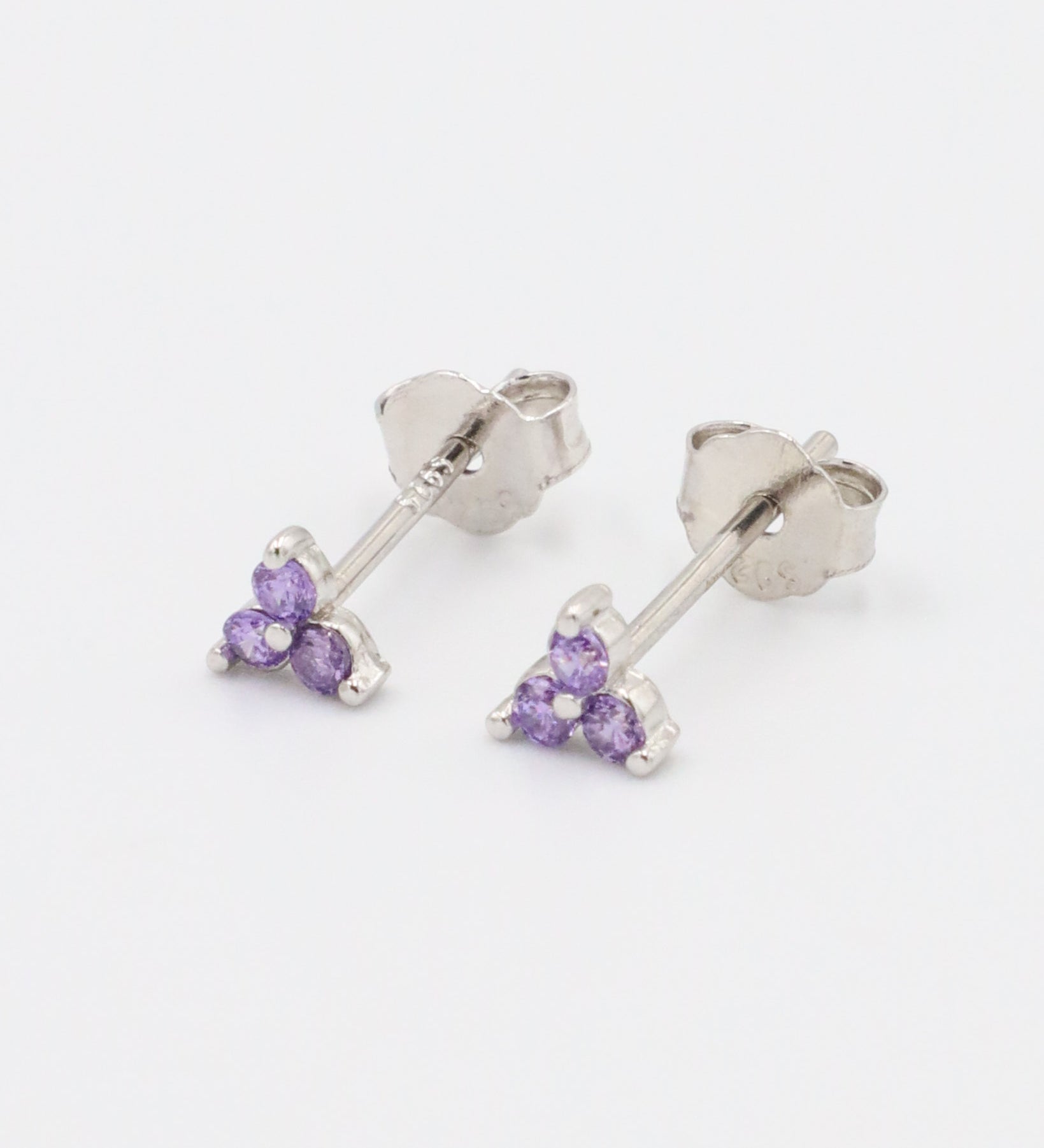 A pair of Vivian Lavender earrings in sterling silver, featuring three zirconia stones in a delicate lavender hue, designed as stud earrings.