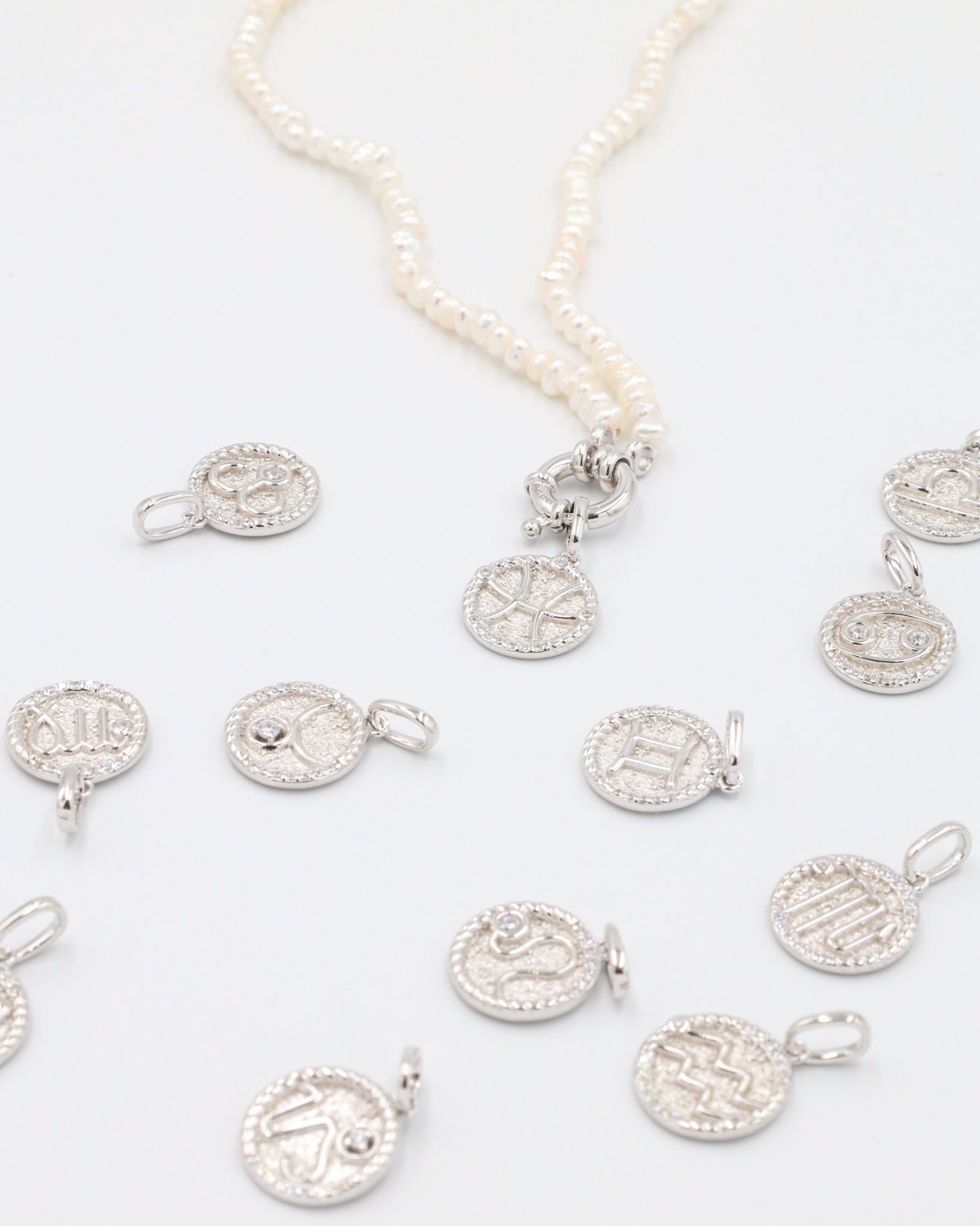 Elegant Zodiac silver pendant set, highlighting all astrological signs in rhodium-plated sterling silver with zirconia stones.
