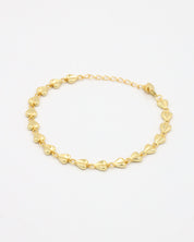 A gold bracelet with a heart-shaped pattern on a white background