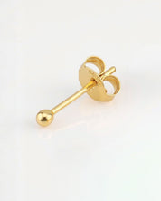 Gold earring on a light gray background