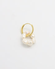 A single gold hoop earring with white pearls attached to it, displayed on a white background.
