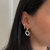 Close-up of a styled ear featuring the Addy Earring in the lobe, Jean Earring in the second lobe, Fleur stud in the third lobe, and the sparkly Jean hoop in the tragus – all from ruru. studios.