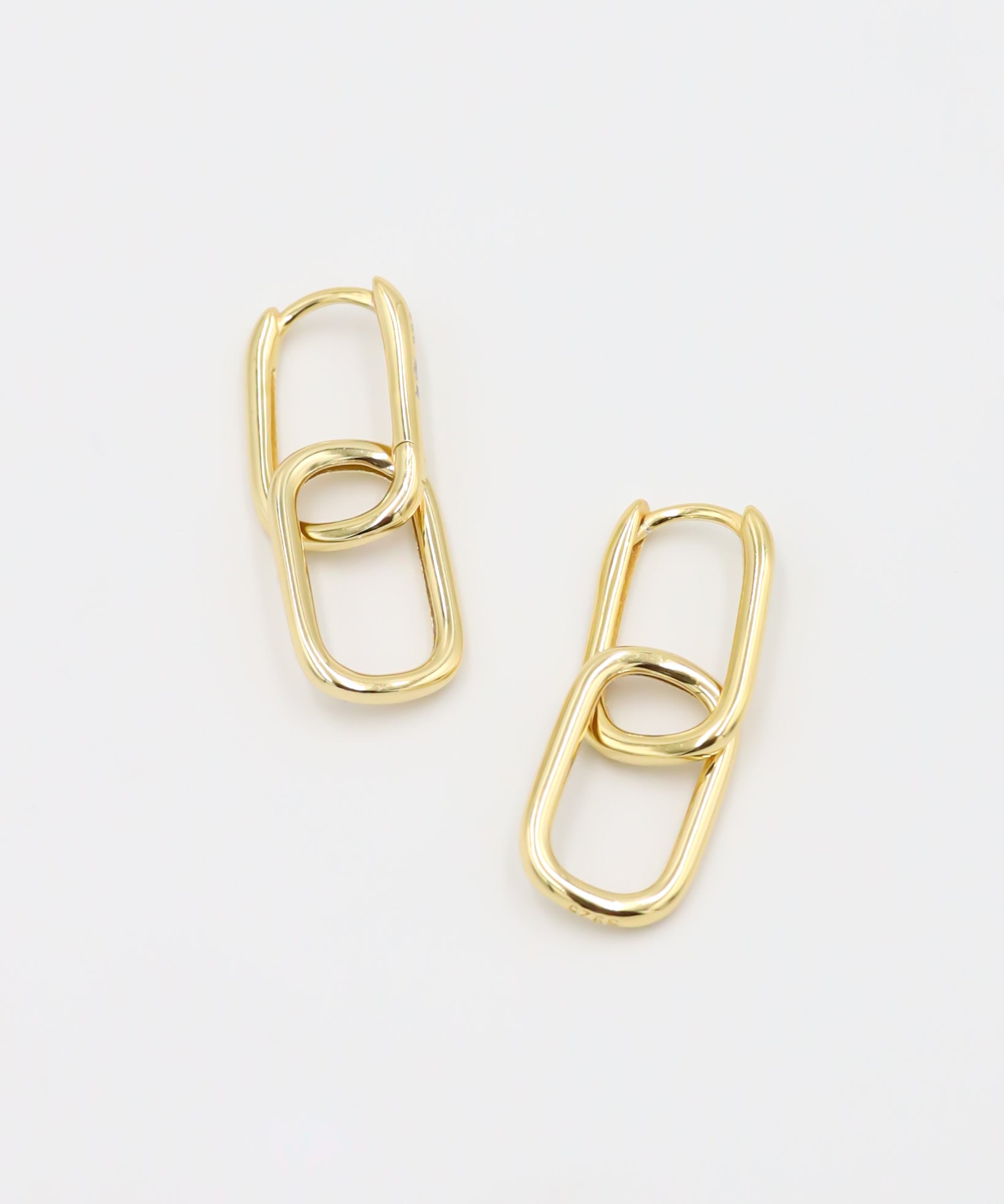 A pair of gold-colored hoop earrings with a hinged clasp, displayed against a white background.