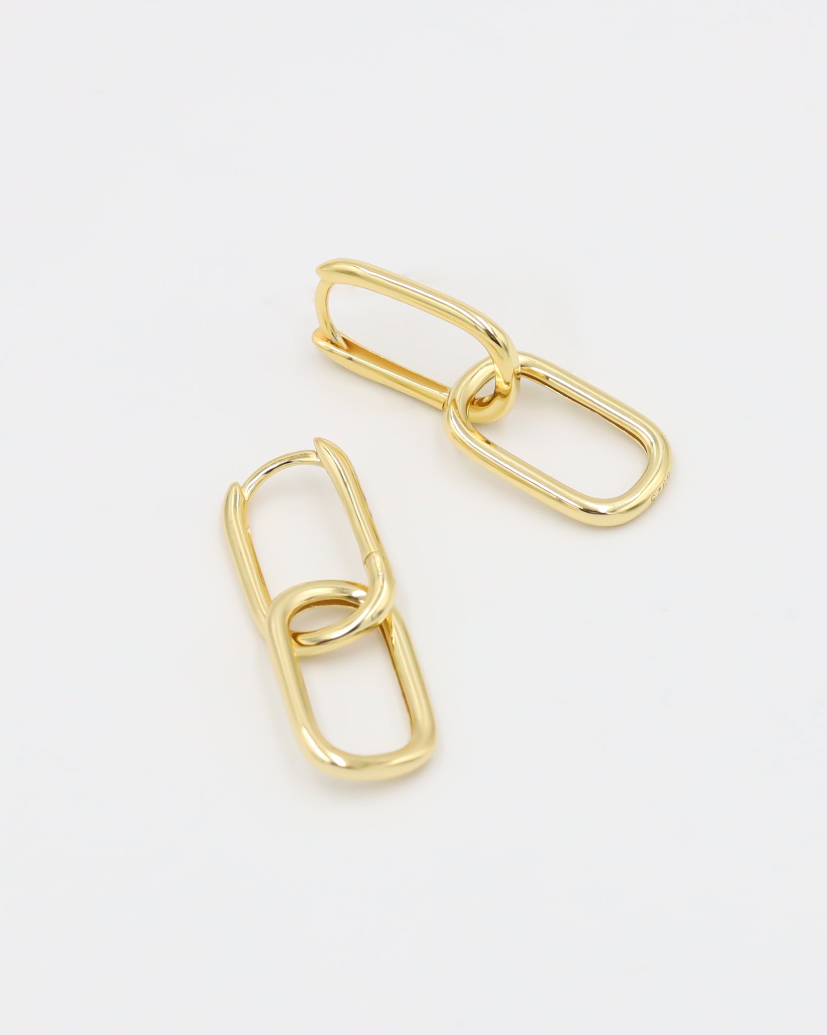 A pair of gold-colored hoop earrings with a hinged clasp, displayed against a white background.