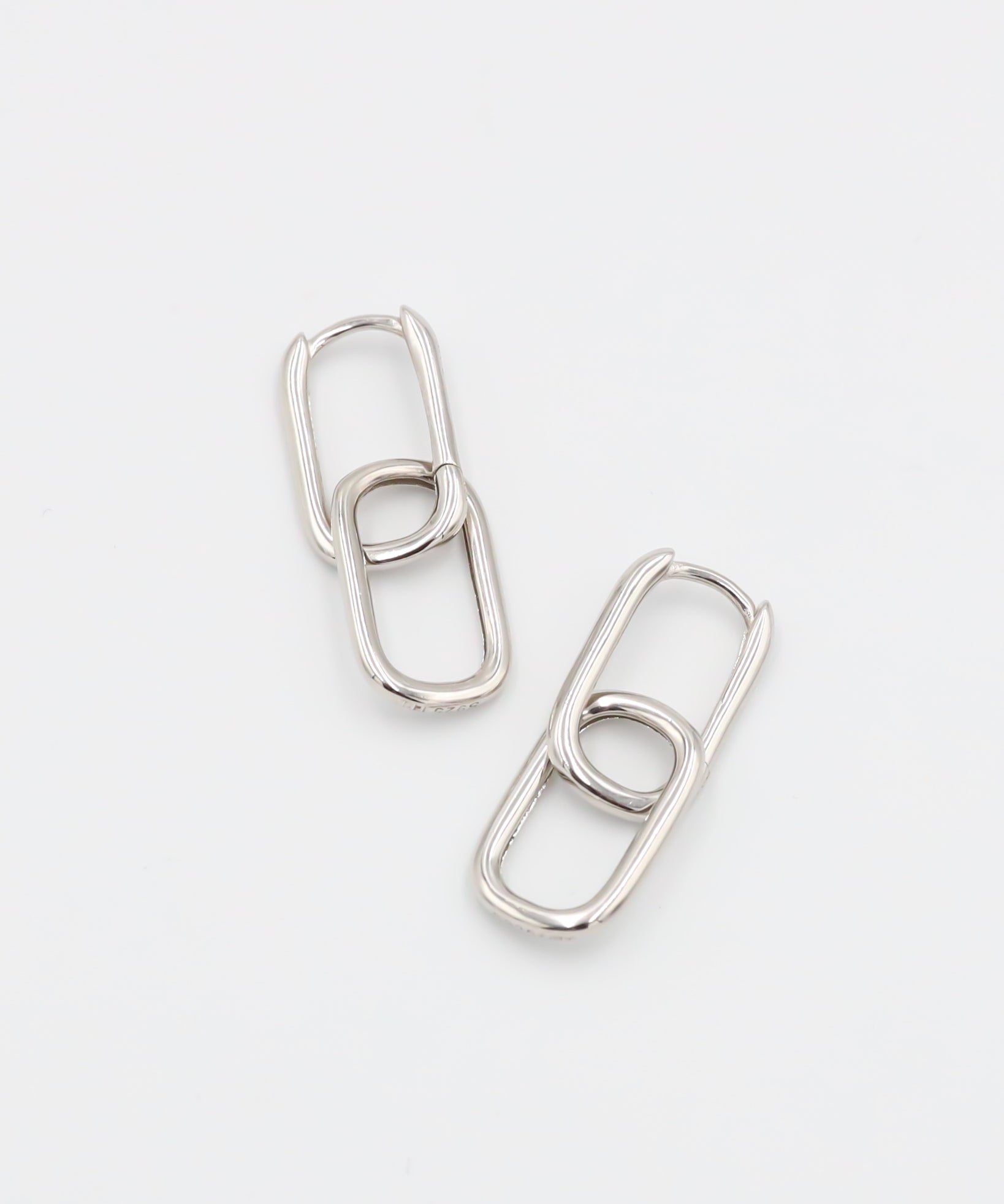 A pair of silver hoop earrings with a hinged clasp, displayed against a white background.