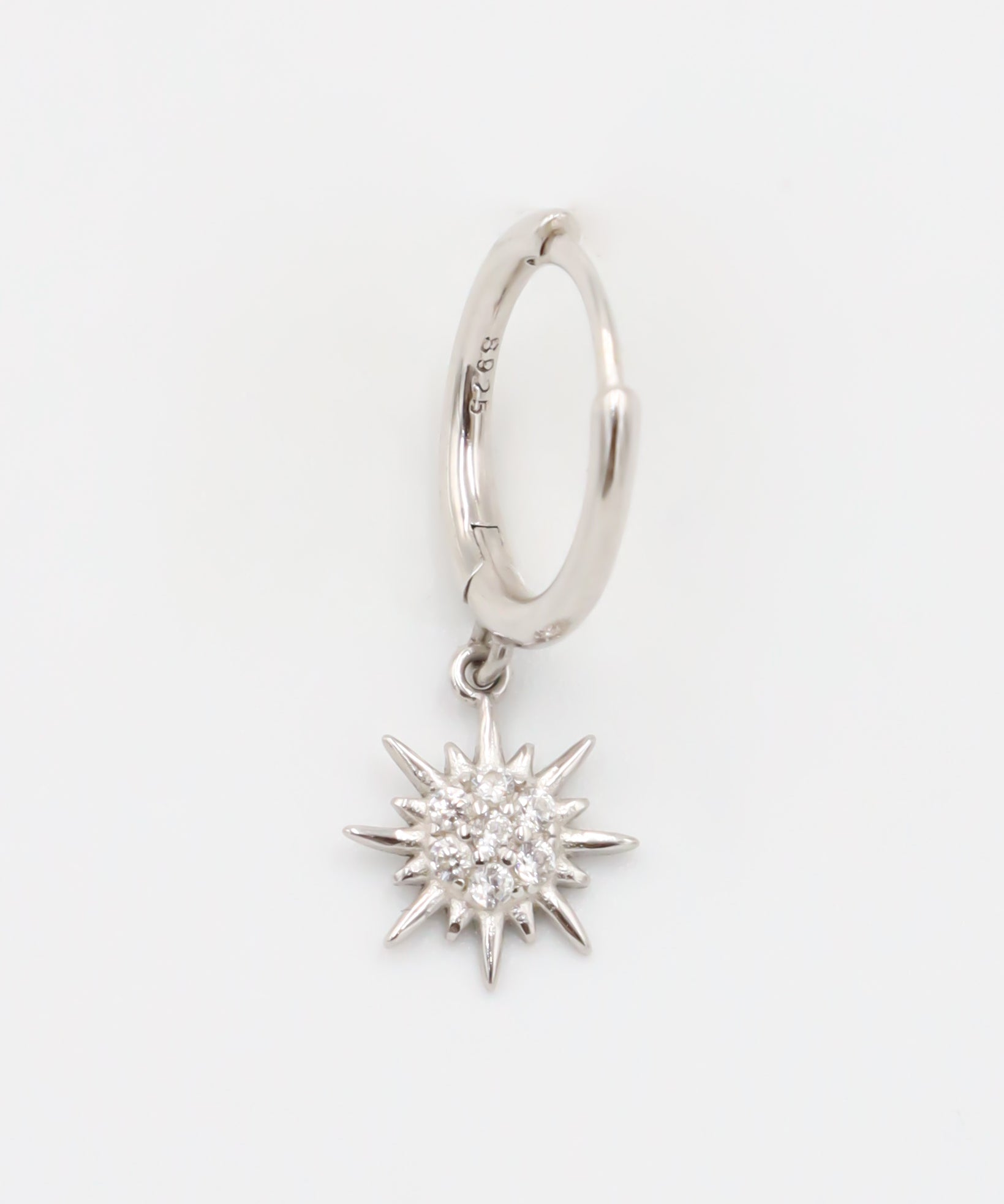 A silver hoop earring with a star-shaped charm attached to it, displayed against a white background.