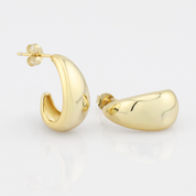 Gold hoop earrings on a light gray background