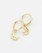 A gold-colored hoop earring with a crescent moon charm attached, set on a white background.