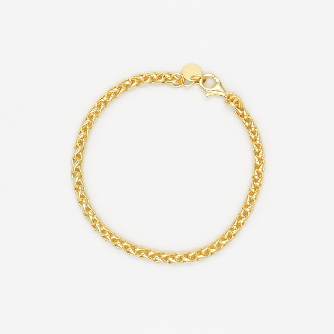 A gold-colored bracelet with a clasp, displayed against a white background.