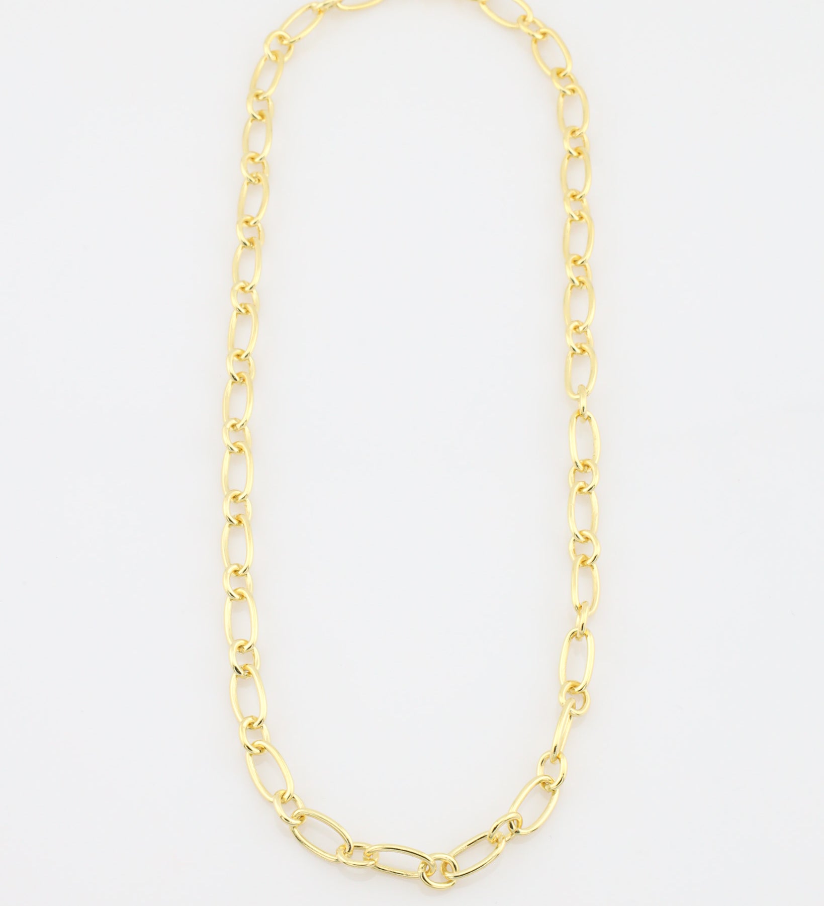 Gold chain necklace on a light gray background