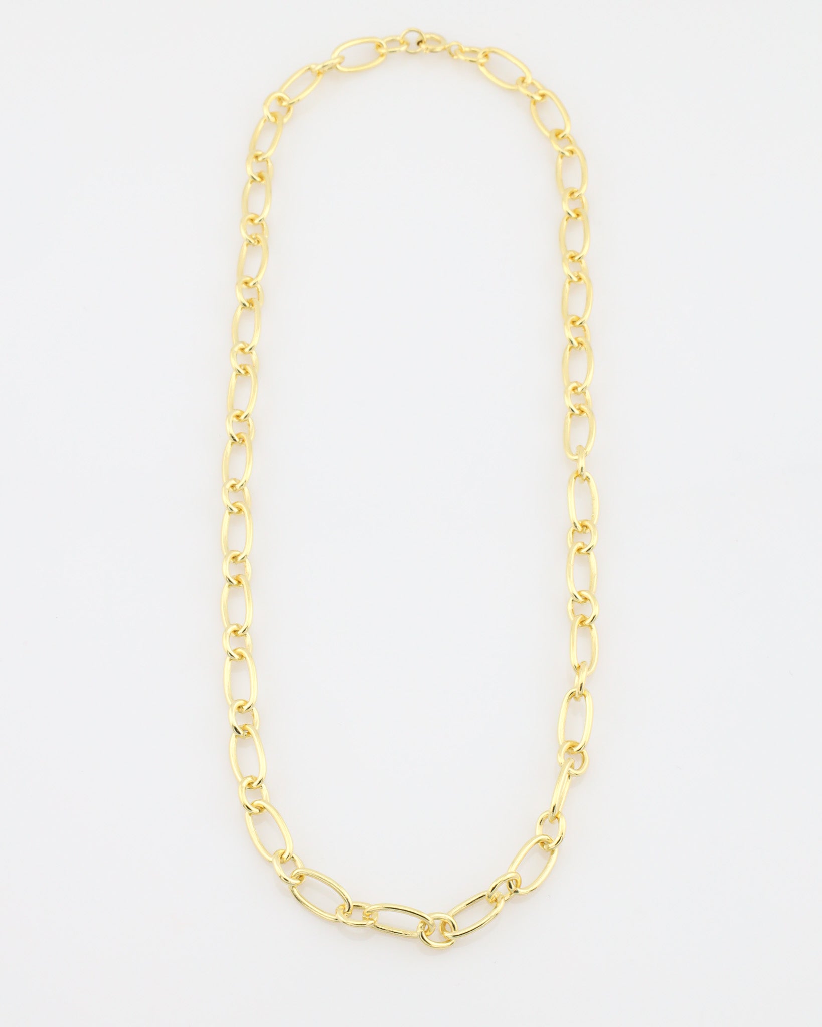 Gold chain necklace on a light gray background