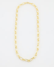 Gold chain necklace on a light gray background