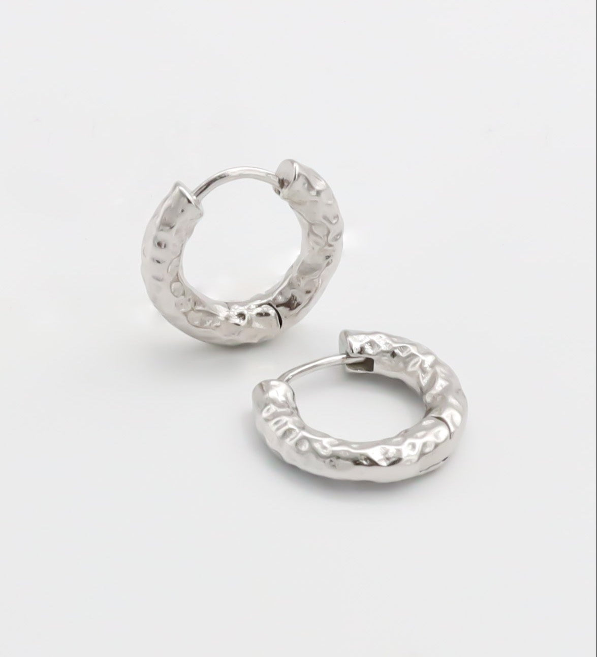 Pair of silver hoop earrings on a light gray background
