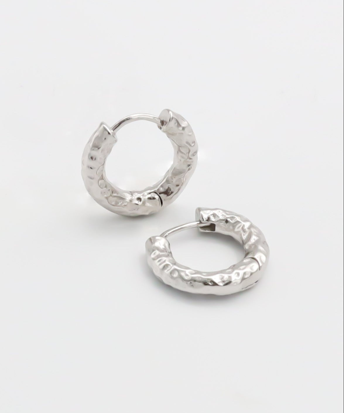 Pair of silver hoop earrings on a light gray background