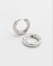 Pair of silver hoop earrings on a light gray background