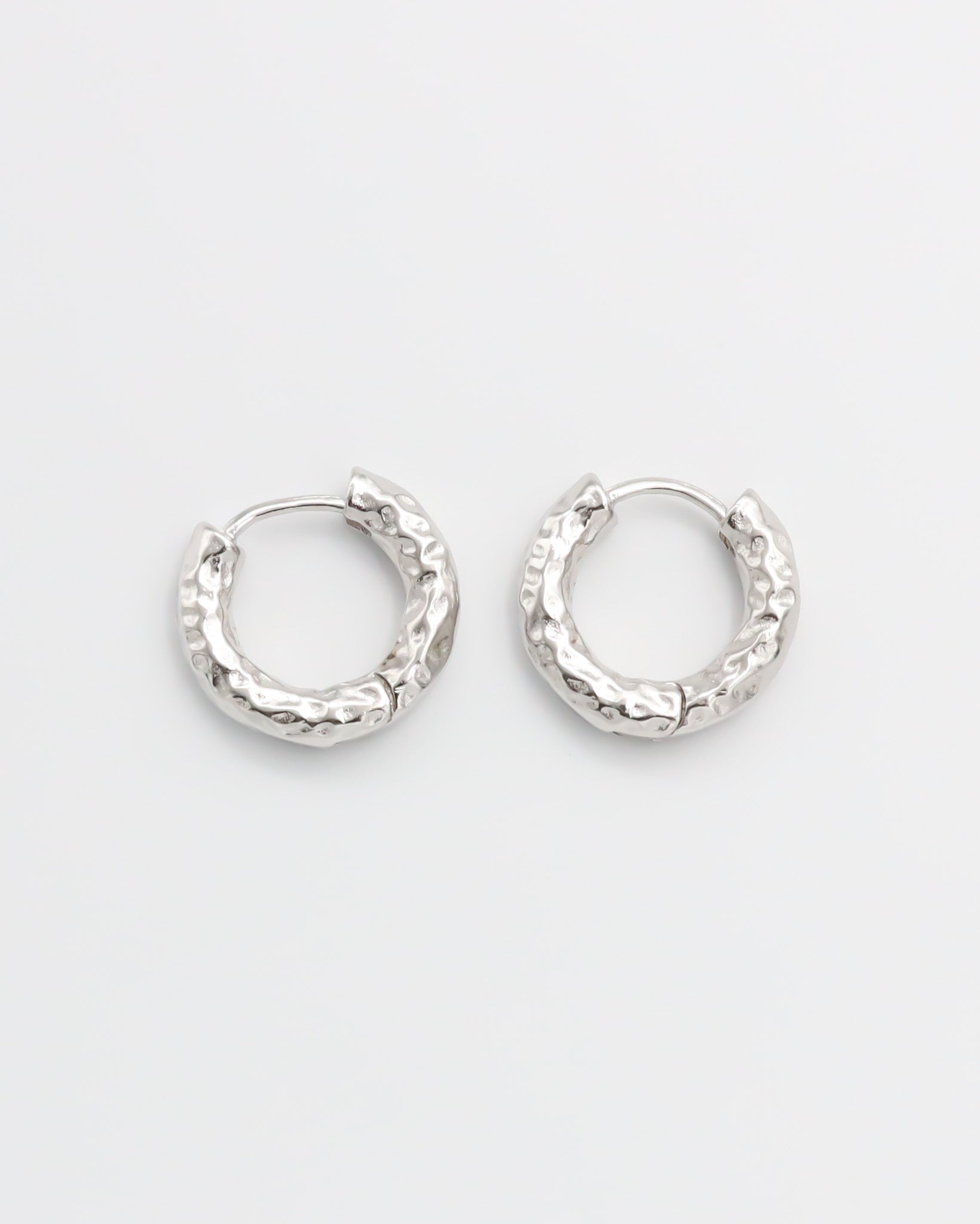 A pair of silver hoop earrings with a hinged clasp, displayed against a white background.