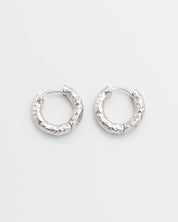 A pair of silver hoop earrings with a hinged clasp, displayed against a white background.