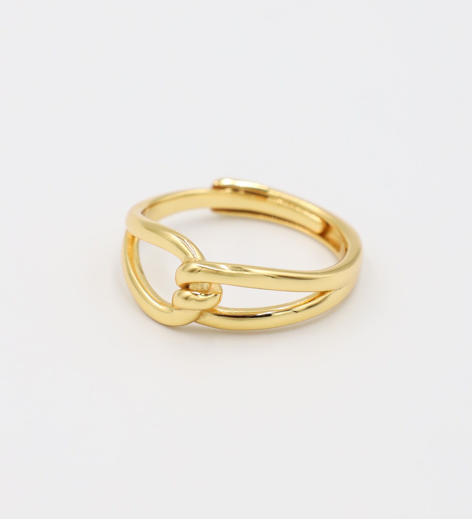 A gold-colored ring with a simple design, featuring two loops that are not connected.