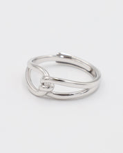 A simple silver ring with a unique design, featuring a knot-like pattern on a white background.