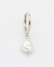 A silver-colored hoop earring with a white pearl charm attached to it.
