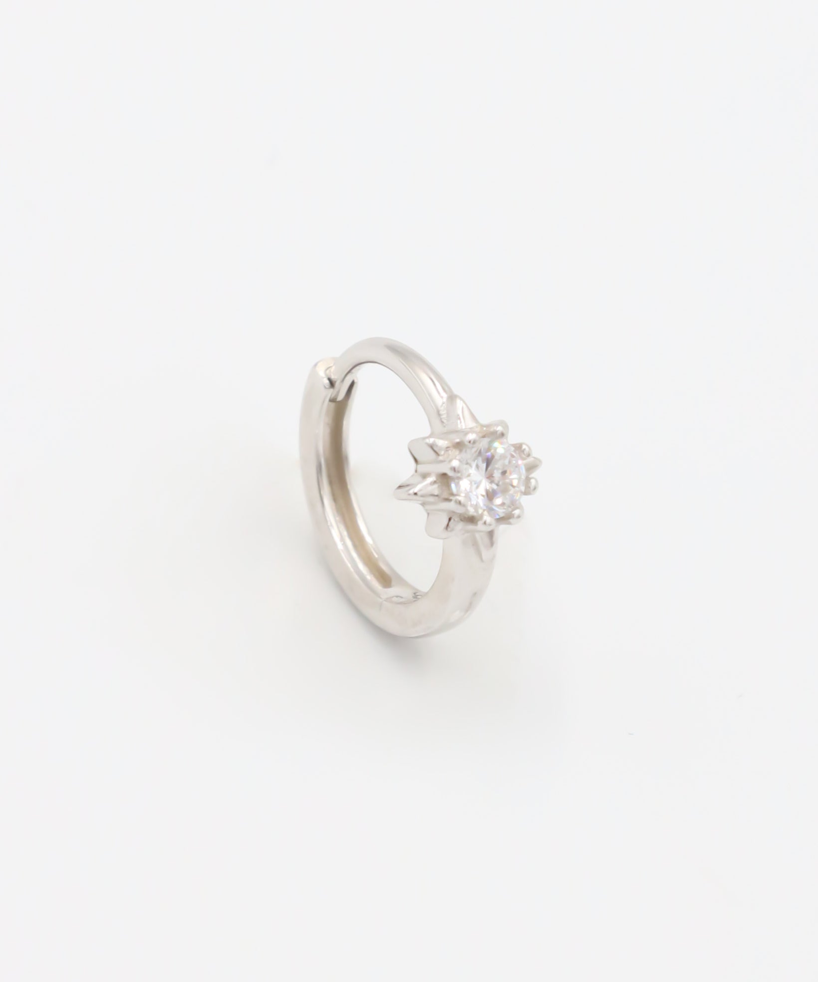 A silver hoop earring with a hinged clasp and no visible gemstone.