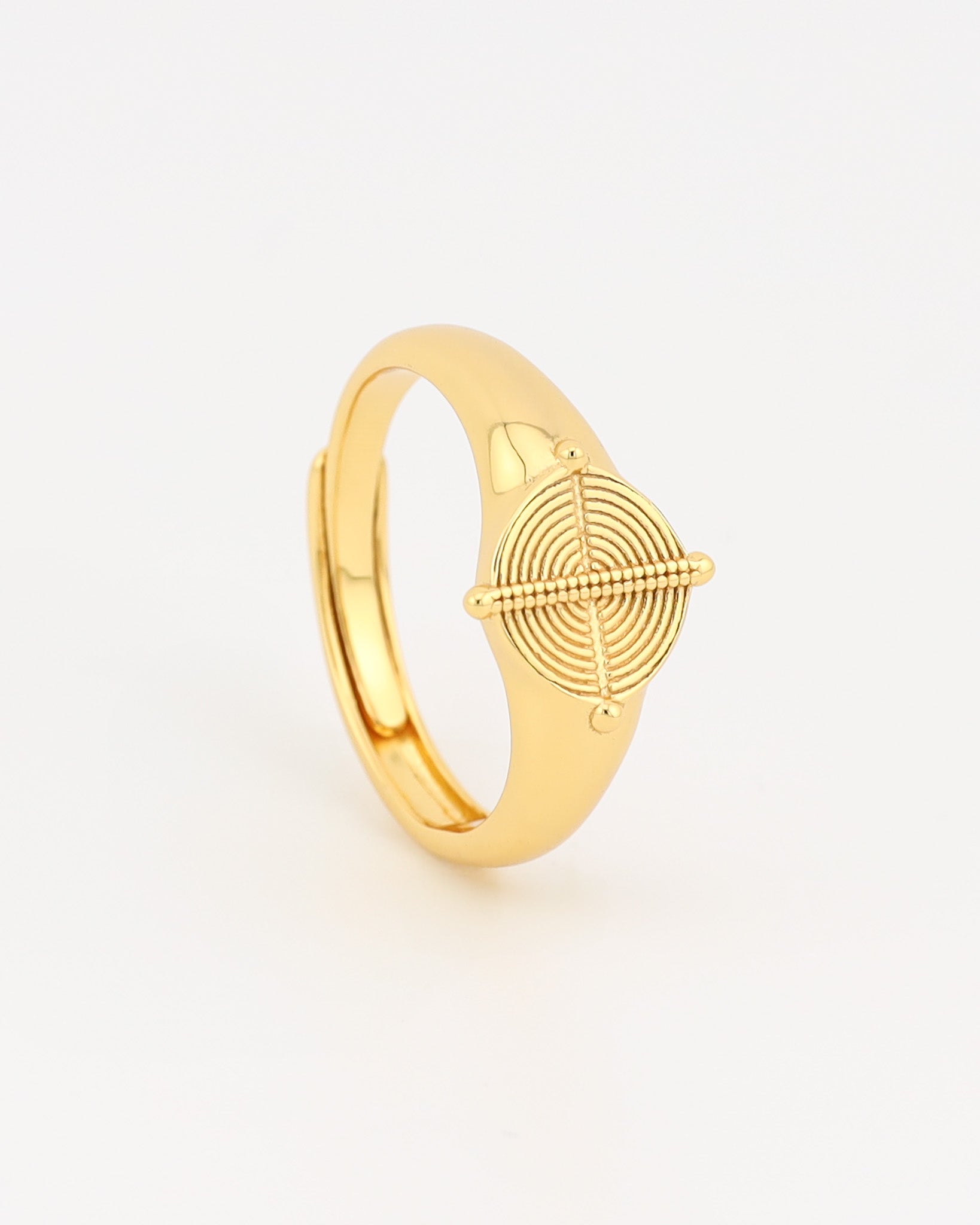 Gold ring with geometric design on a light gray background