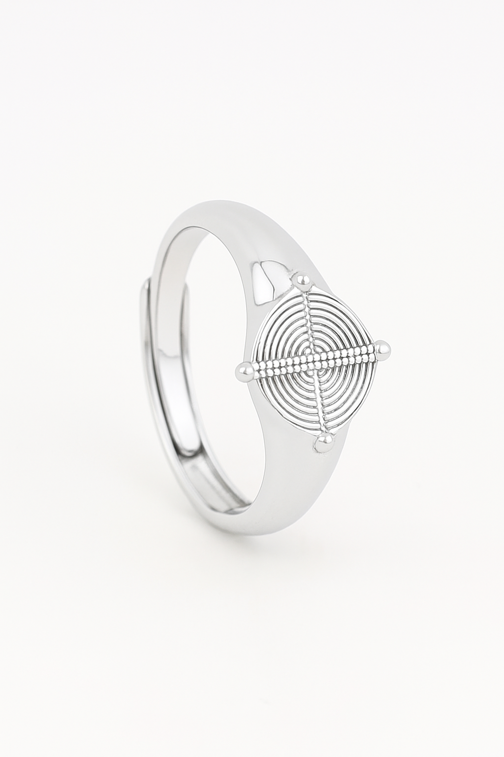 Silver ring with geometric design on a light beige background