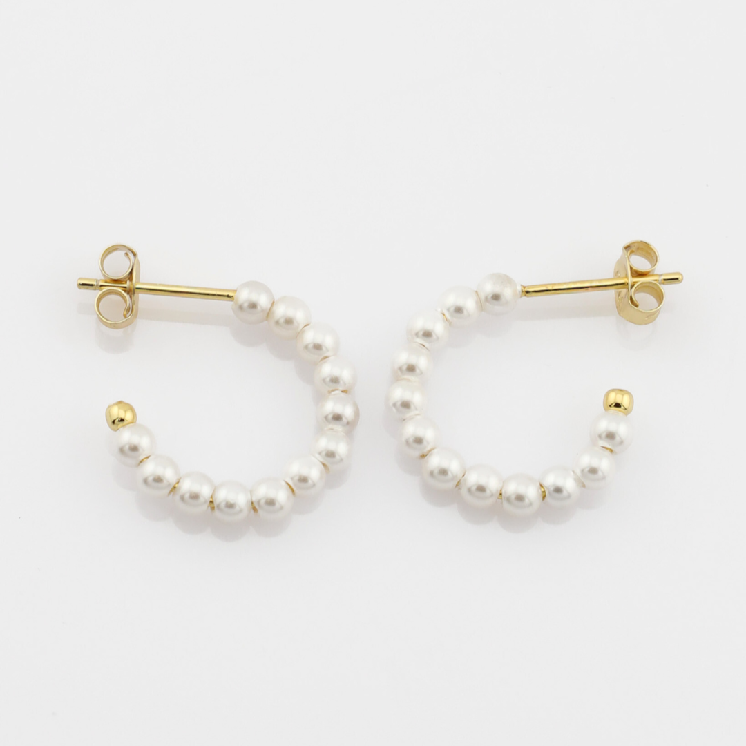 Pearl hoop earrings with gold accents on a white background