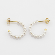 Pearl hoop earrings with gold accents on a white background